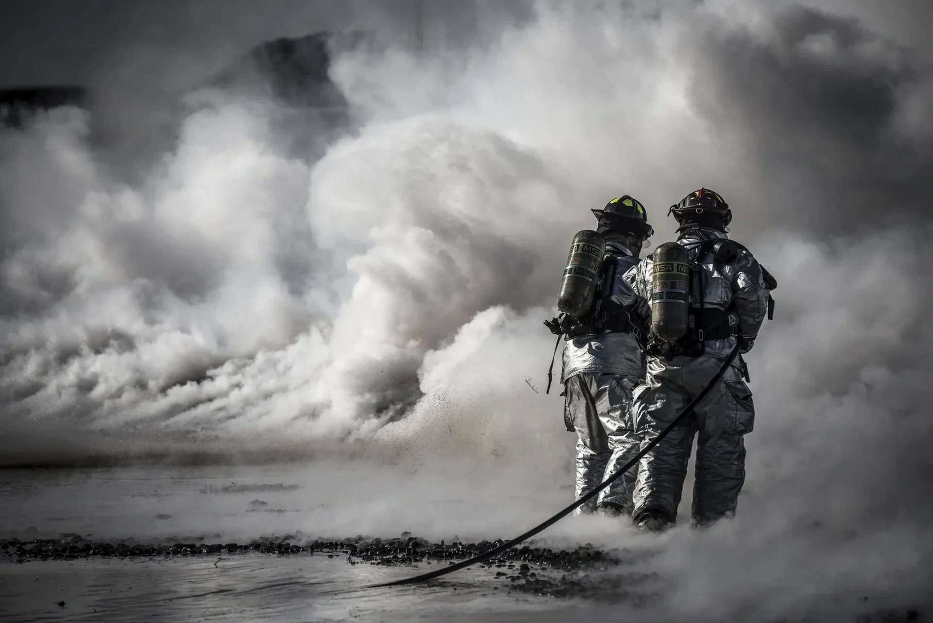 Emergency responders performing industrial pump operations training using fire apparatus and fire water systems to improve emergency response readiness and water supply management.